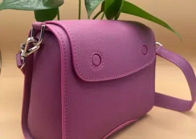 Sac à bandoulière violet avec plante en arrière-plan